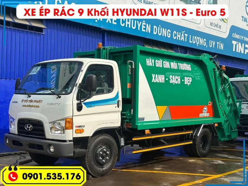 Xe Ép Rác 9 Khối Hyundai - Euro 5 (Máng Xúc) 21 Hình ảnh toàn cảnh xe ép rác Hyundai Mighty W11S 9 khối màu trắng và xanh lá cây, đạt tiêu chuẩn khí thải Euro 5, đỗ trước showroom, sẵn sàng để giao hàng.