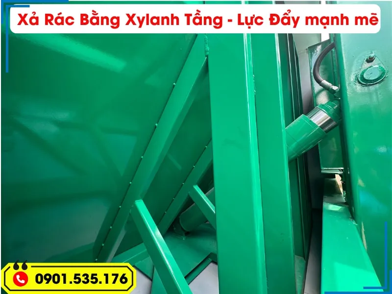 Xe Ép Rác 9 Khối Hyundai - Euro 5 (Máng Xúc) 25 Hệ thống xả rác bằng xy lanh tầng bên trong thùng xe ép rác Hyundai 9 khối, có màu xanh lá cây, thể hiện lực đẩy mạnh mẽ và hiệu suất cao.